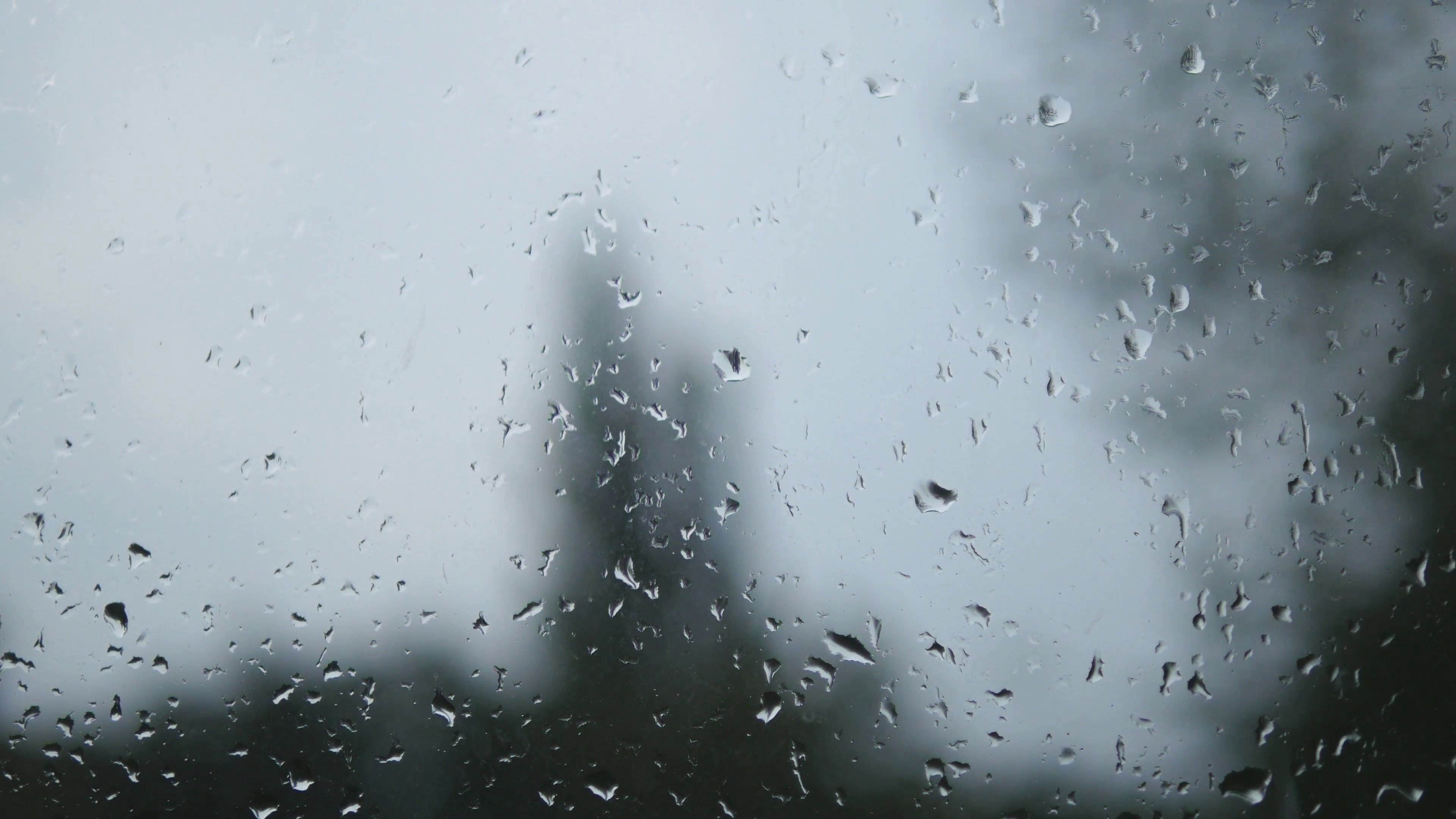 Rain drops on window glass with blur background. Blurred tree and sky. Rainy  days, rain running down window, bokeh Stock Video Footage - VideoBlocks 3840x2160